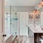 Bathroom with two doors and a tub and walk in shower and double vanity and the right bathroom door size