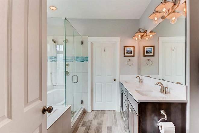 Bathroom with two doors and a tub and walk in shower and double vanity and the right bathroom door size