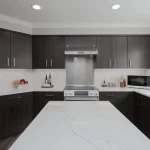 Kitchen with the correct kitchen walkway spacing and dark slab cabinets and stone kitchen island