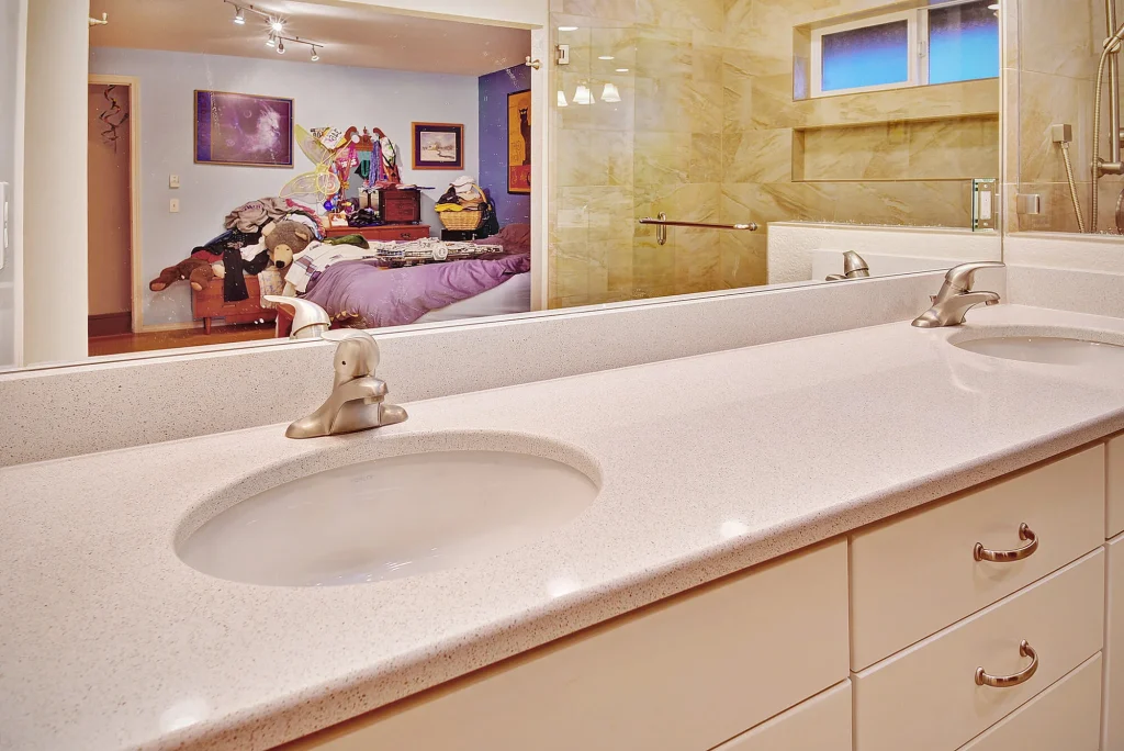 Modern double sink vanity with white countertop and cabinets by Home Run Design Remodel, bathroom large mirror, stylish remodel.